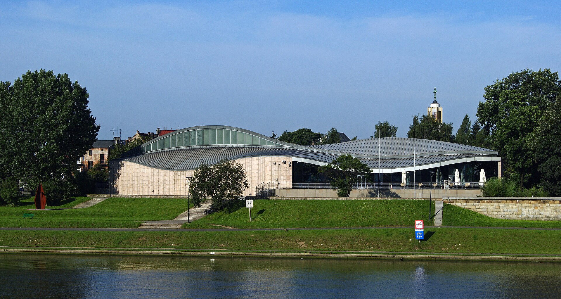 Widok niezwykłej, falującej linii architektury Muzeum Manggha z widokiem brzegu Wisły.