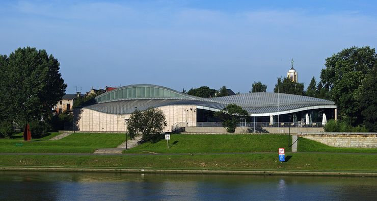 Widok niezwykłej, falującej linii architektury Muzeum Manggha z widokiem brzegu Wisły.