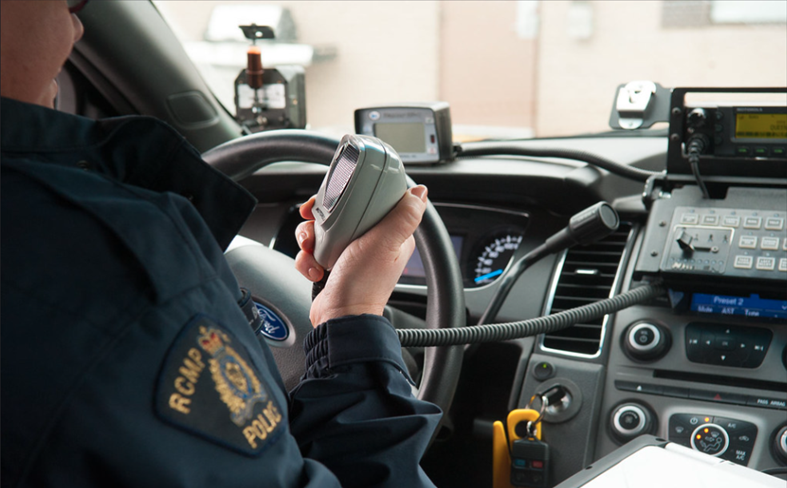 A police officer holding a radio set